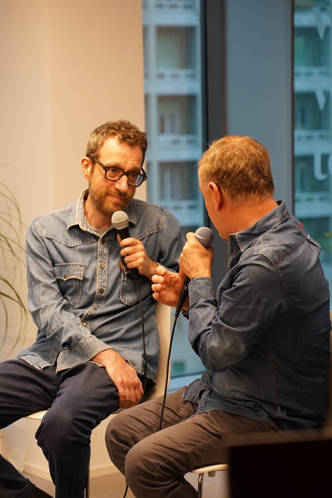 A person holding a microphone and another person talking

AI-generated content may be incorrect.
