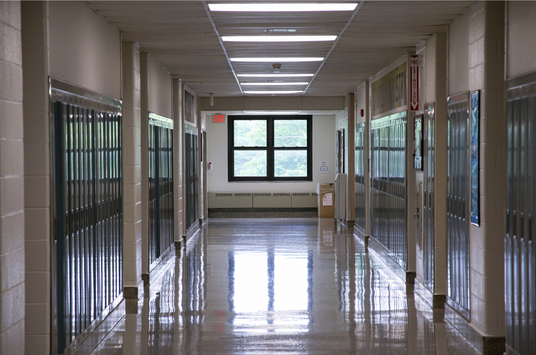 Empty high school hallway with lockers and class photos