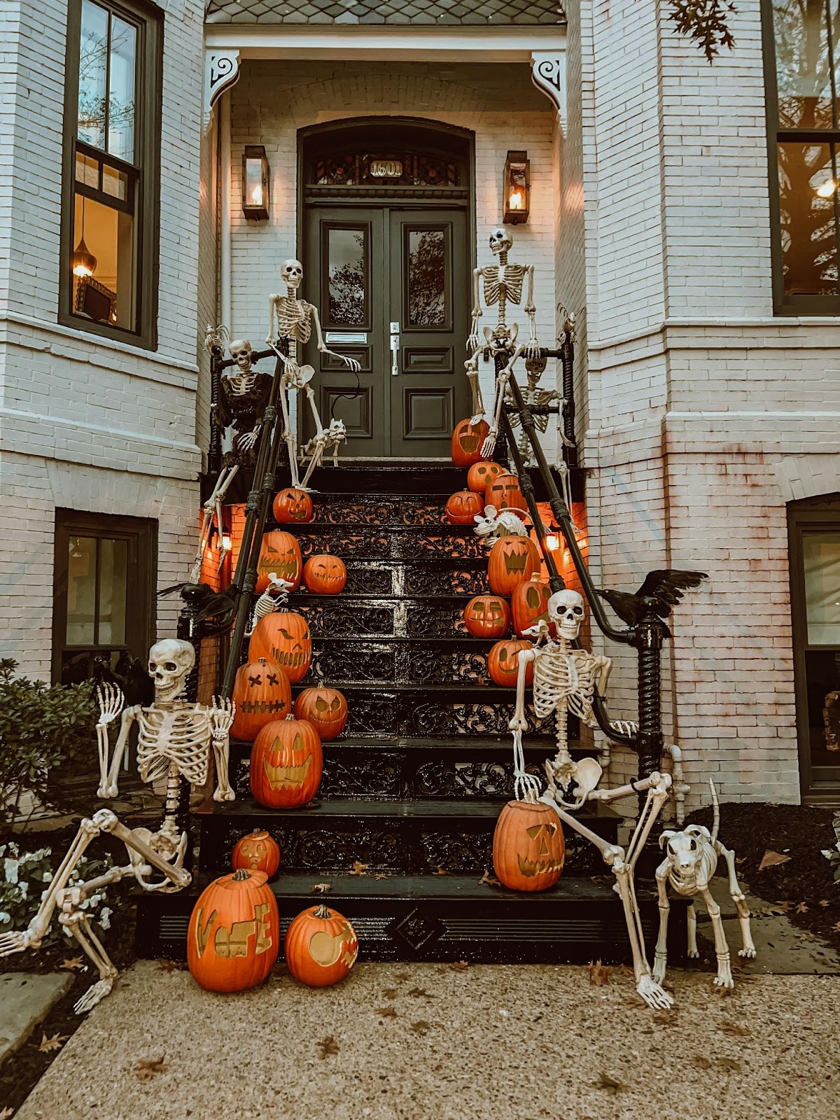 Staircase entrance to townhome covered in festive pumpkins and plastic skeletons