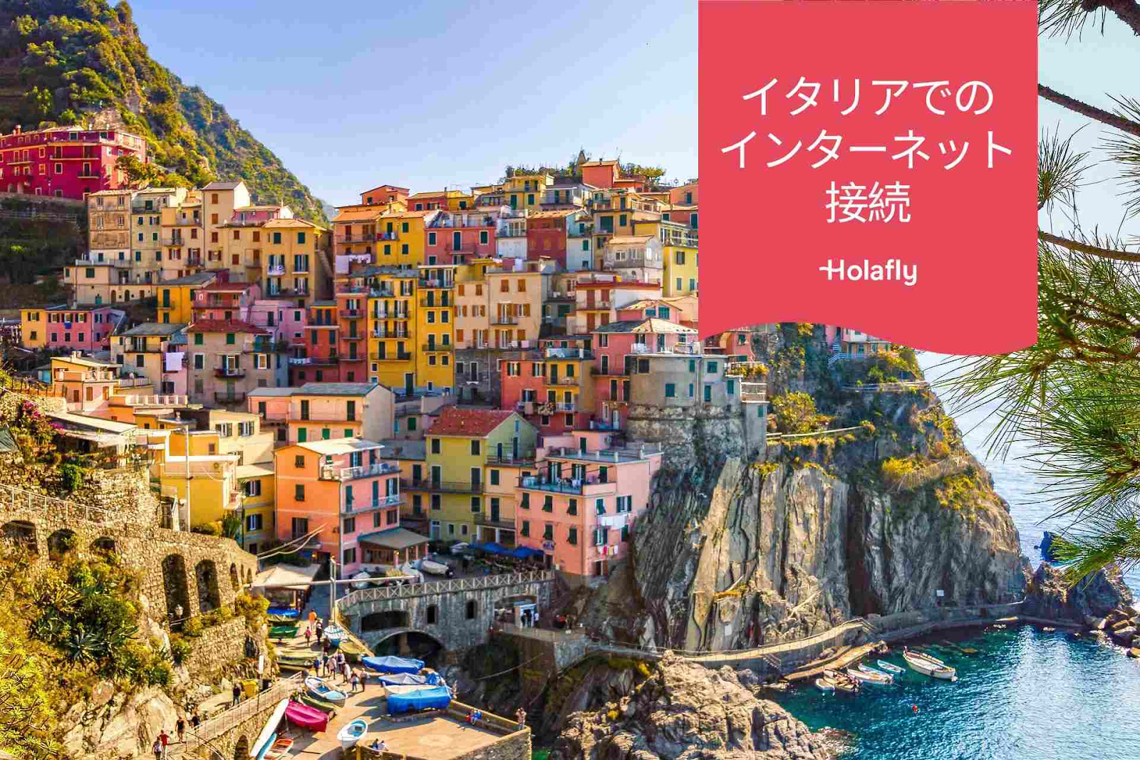 Alt Text:
イタリア、チンクエテッレの崖の上に建つカラフルな家々の景色と、「イタリアでのインターネット接続」をHolaflyが提供することを宣伝する日本語のバナー。
