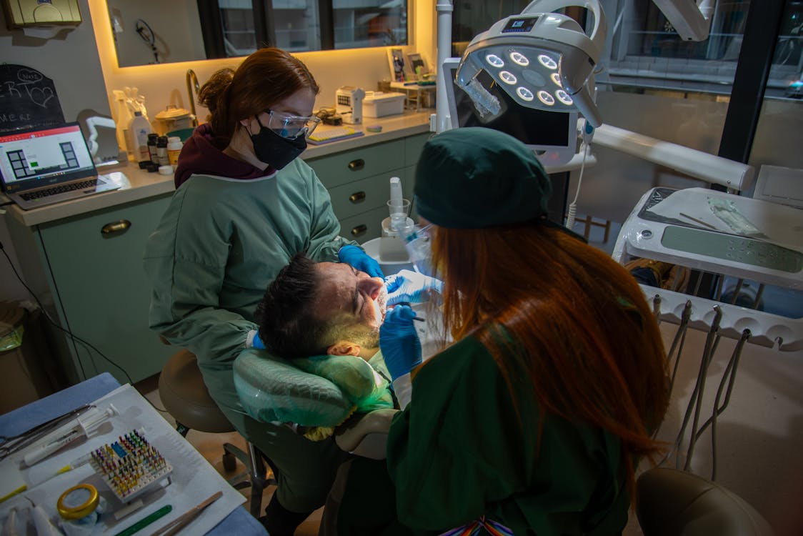 Free Dentists performing a procedure in a contemporary clinic with advanced equipment. Stock Photo