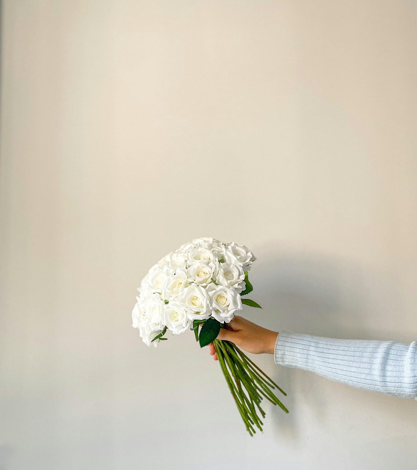 A woman holding a bouquet of white roses | Source: Pexels