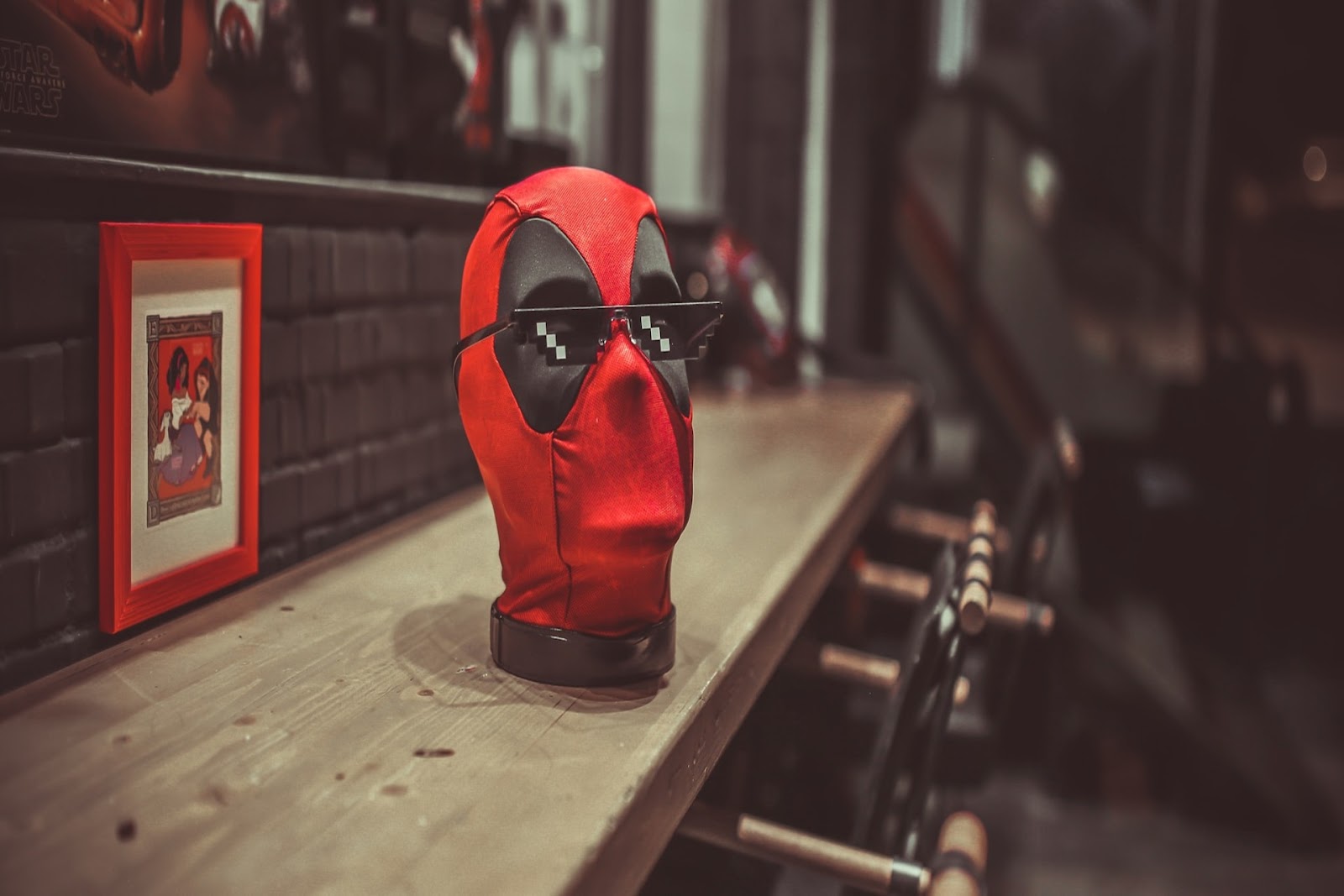 Red and black cosplay mask on a wooden surface.