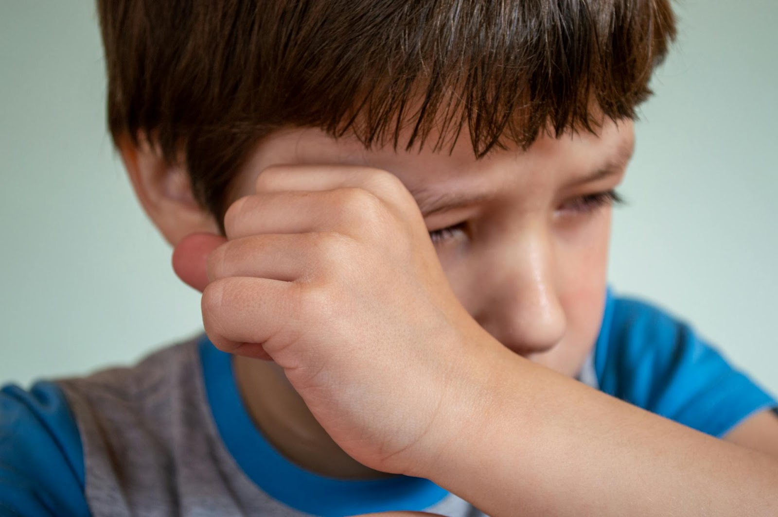 A boy wiping away tears | Source: Pexels