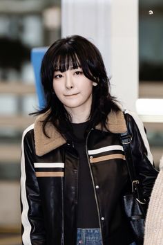 This contains an image of Seulgi  Red Velvet on a black jacket with a touch of brown and white