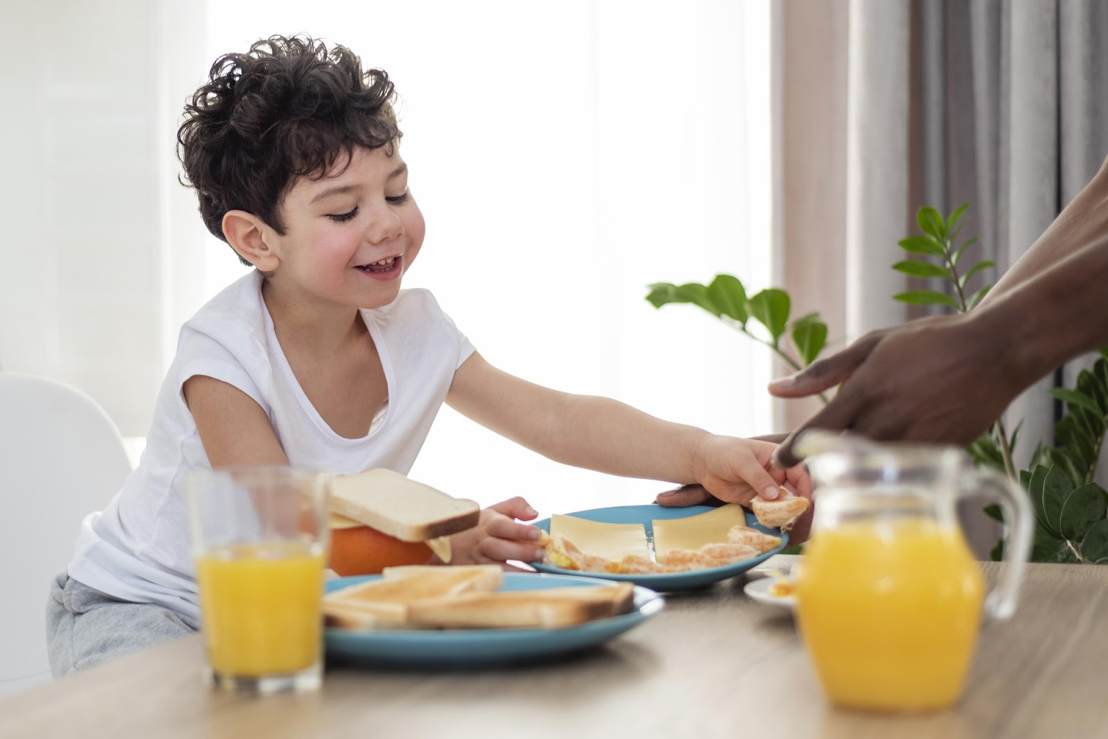 A small boy eating during breakfast