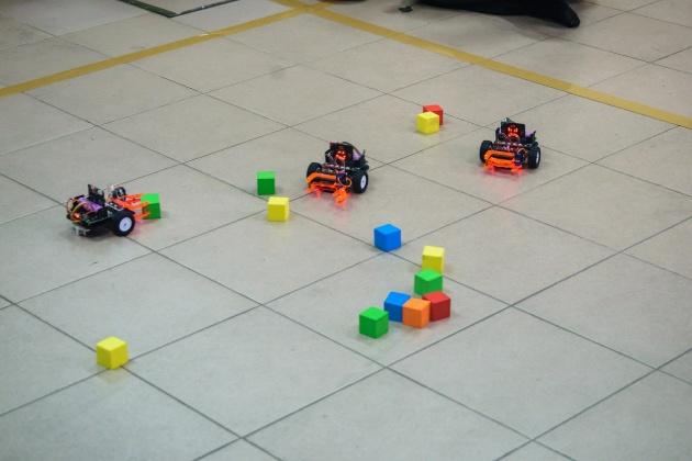 A group of toy cars on a tile floor

Description automatically generated