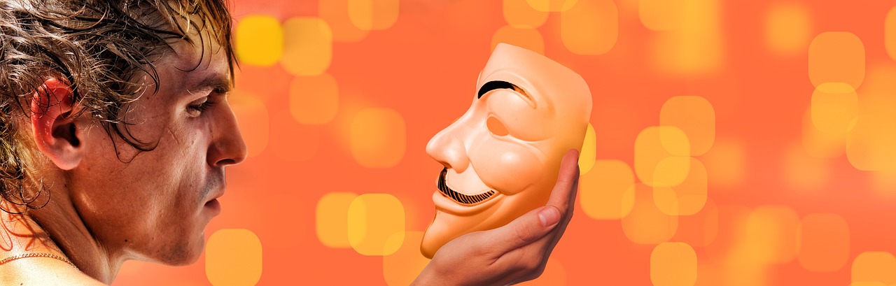 A man looking at a mask. Orange background. 