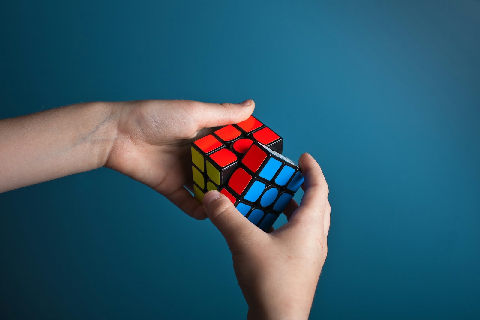 A person gripping a colorful Rubik's Cube, showcasing their puzzle-solving skills and creativity.