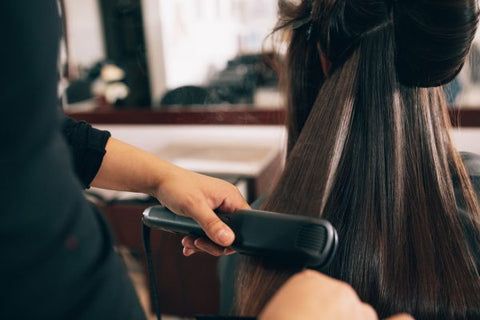 Woman getting her hair straightened