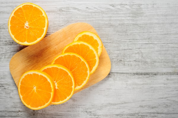 Sliced oranges neatly arranged on a wooden cutting board
