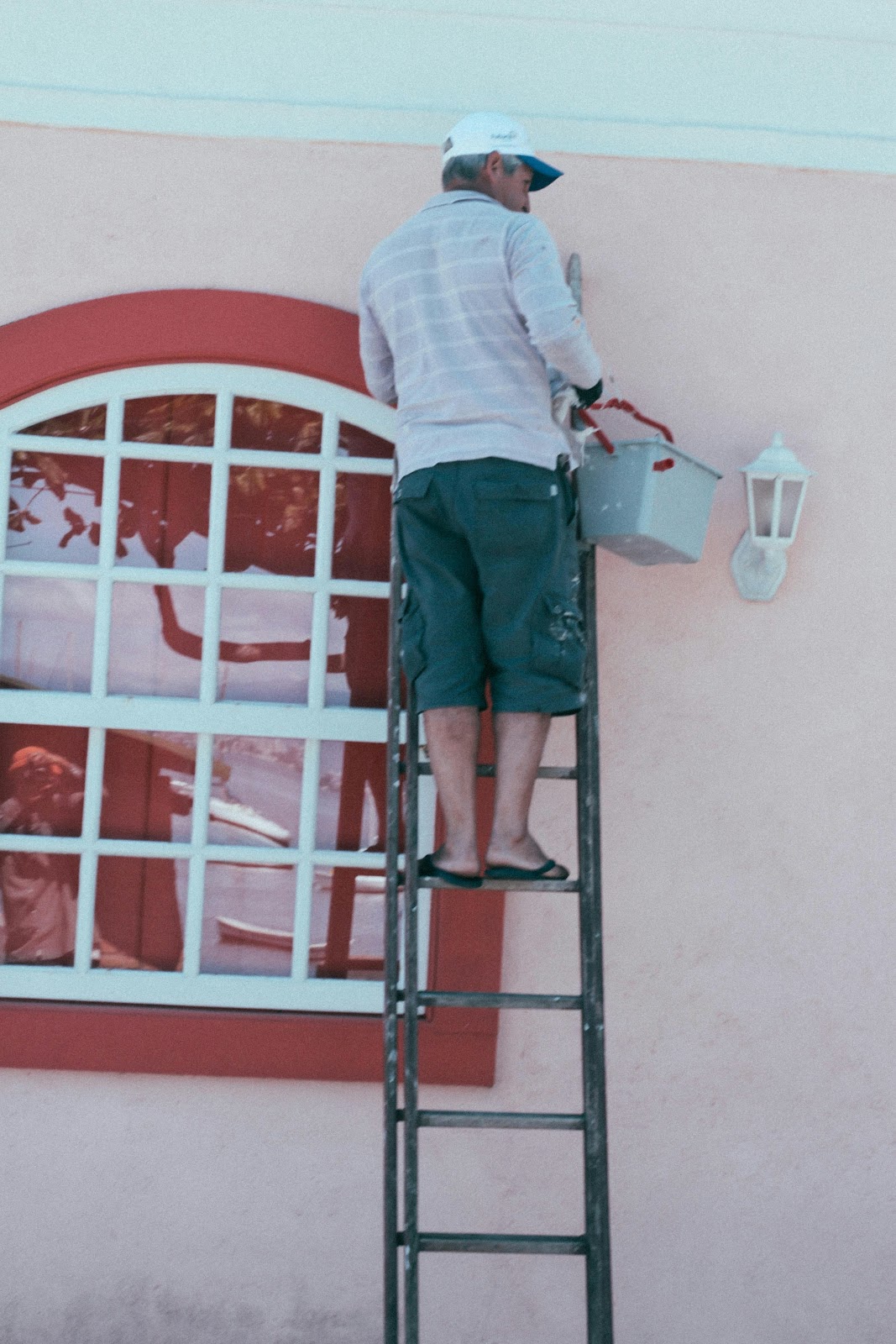 Painter preparing a house for painting by washing it