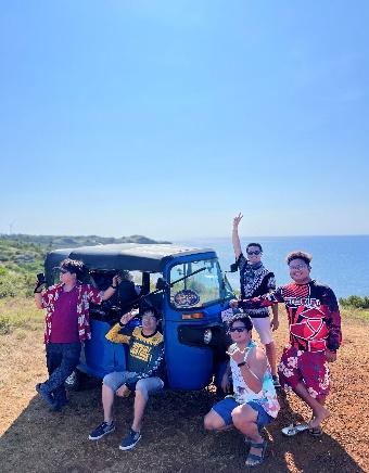 A group of people posing for a picture in front of a blue vehicle

AI-generated content may be incorrect.