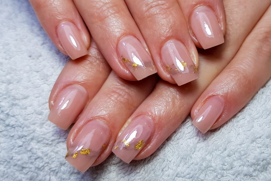 Gold leaf accents bring luxury to a refined French nail tip design.