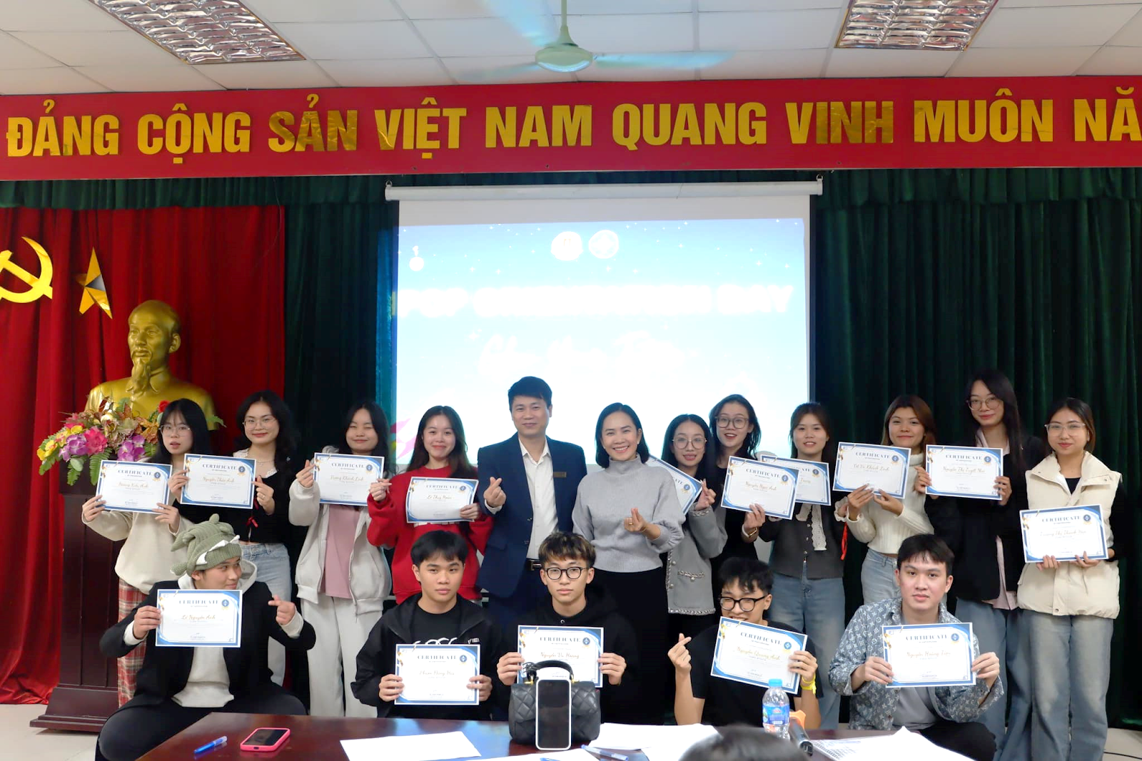 A group of people holding up certificates

Description automatically generated