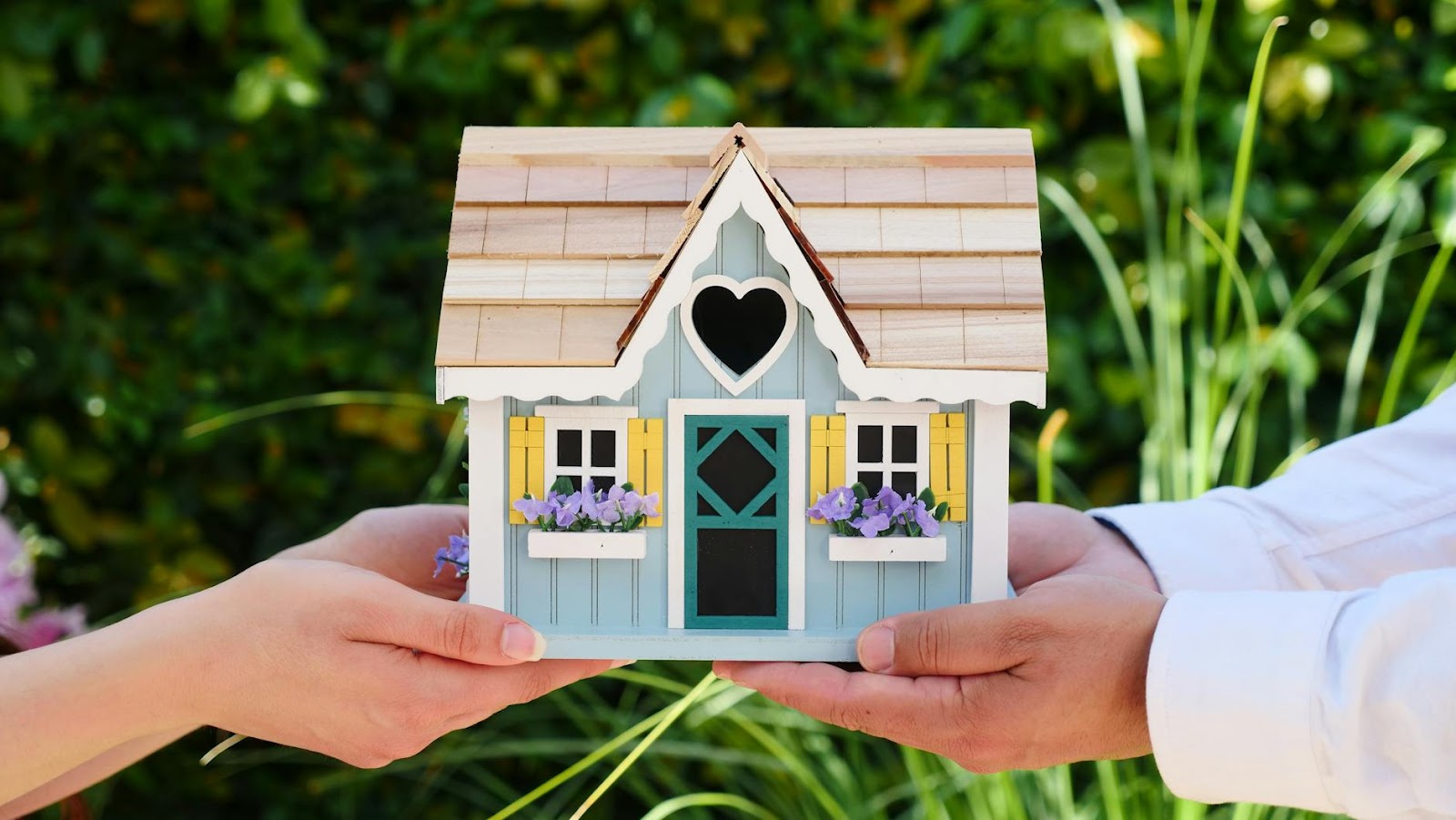 https://www.pexels.com/photo/people-holding-miniature-wooden-house-7578939/