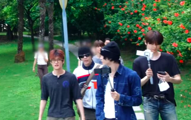 This contain a picture of the RIIZE members and Sungchan looking at his phone