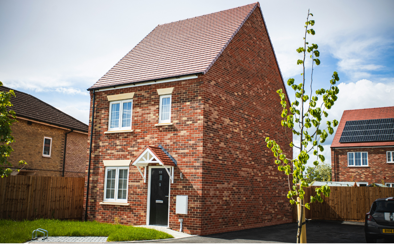 A brick house with a black doorDescription automatically generated