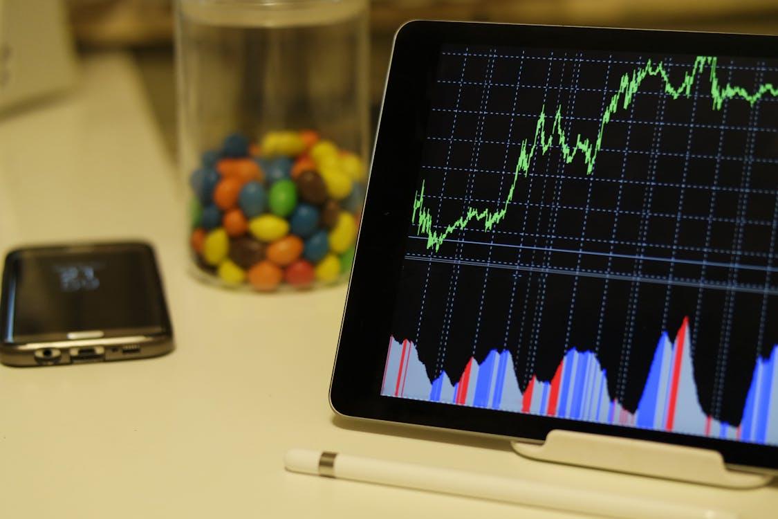 Free White Android Tablet Turned on Displaying a Graph Stock Photo