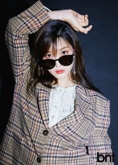 This contains a picture of  Yulhee in a suit and sunglasses poses for the camera with her hands behind her head