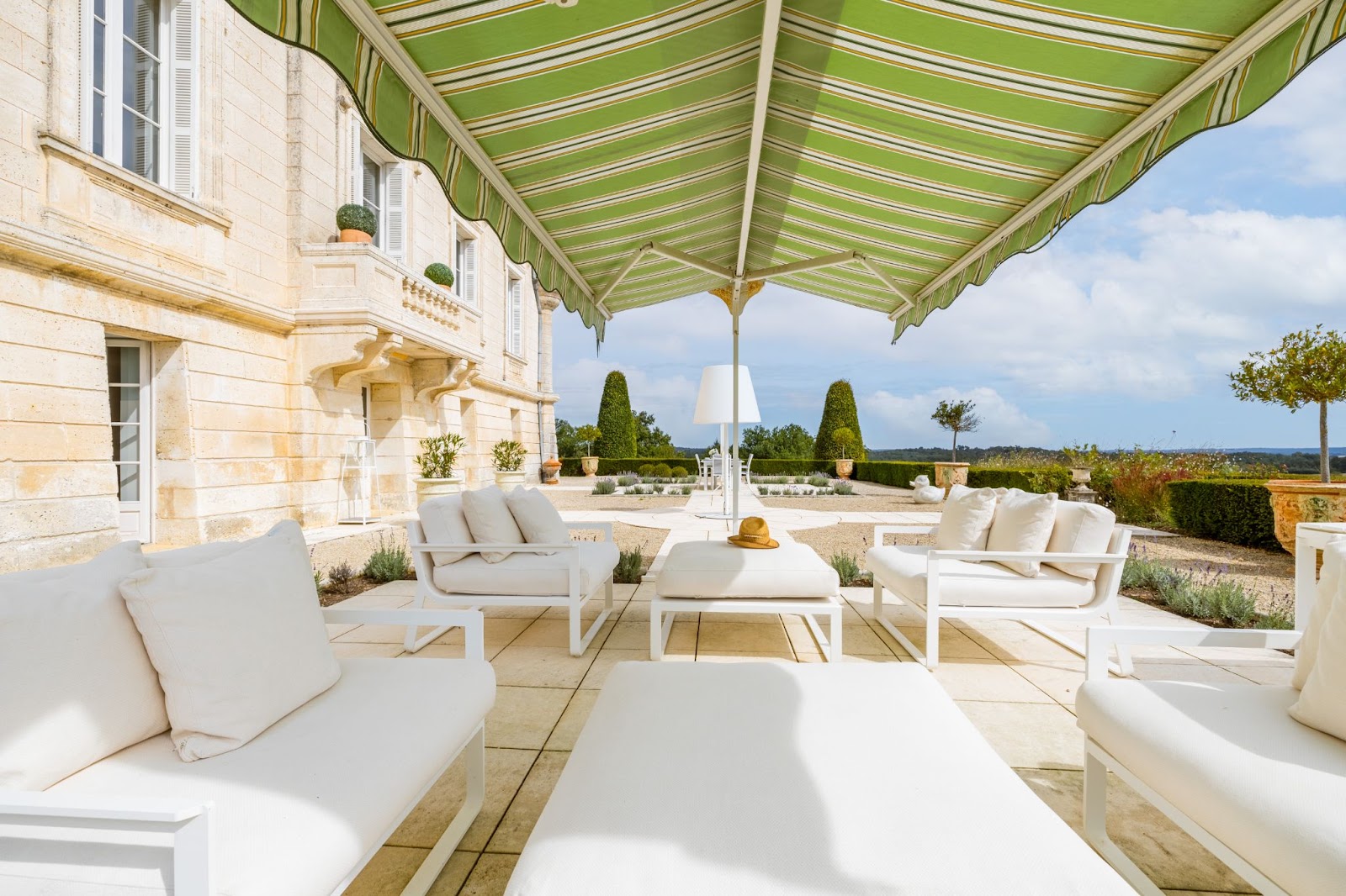 Château de Lasfonds terrace with white seating and countryside view.