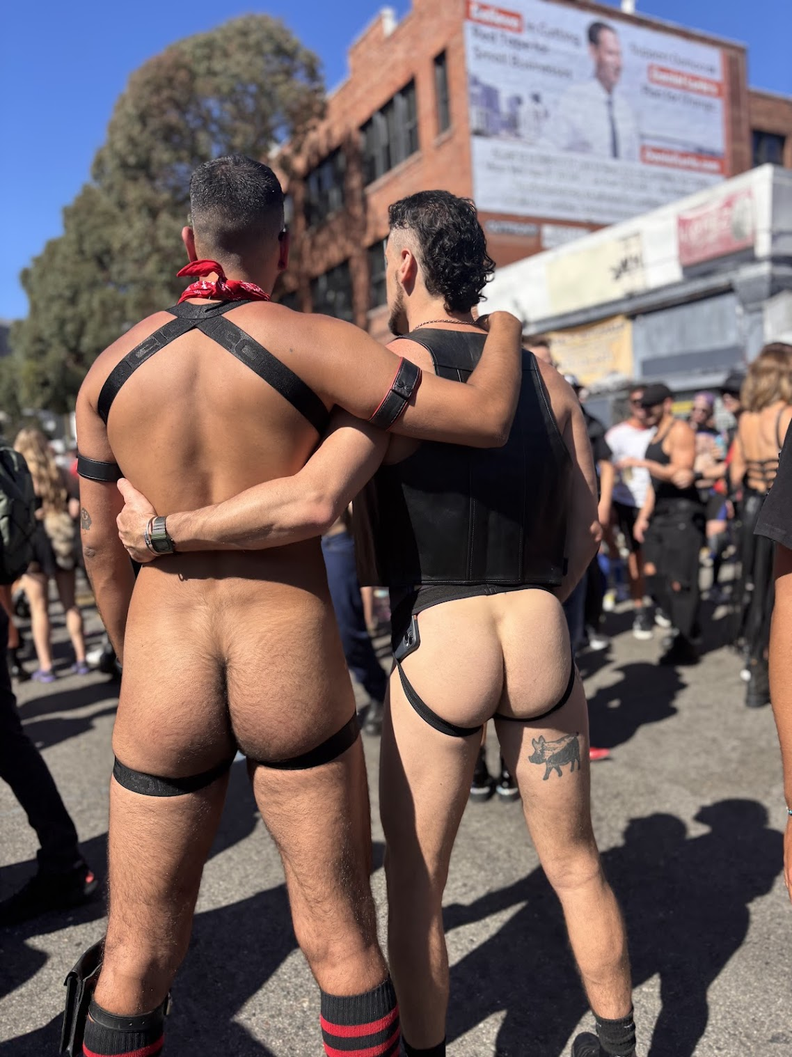 gay xxx onlyfans creator Phil showing off his hairy gay bubble butt in leather bdsm harness with gay hookup friend in leather fetish vest and jockstrap during 2024 folsom street fair