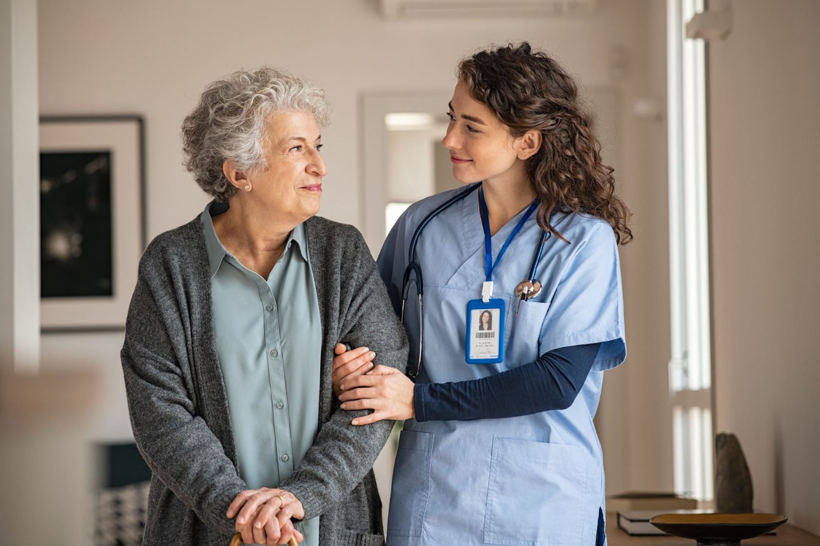 A memory care associate helps a resident go for a walk.