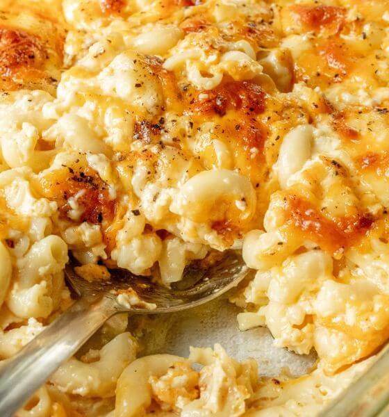 Homemade macaroni and cheese in baking dish with serving spoon