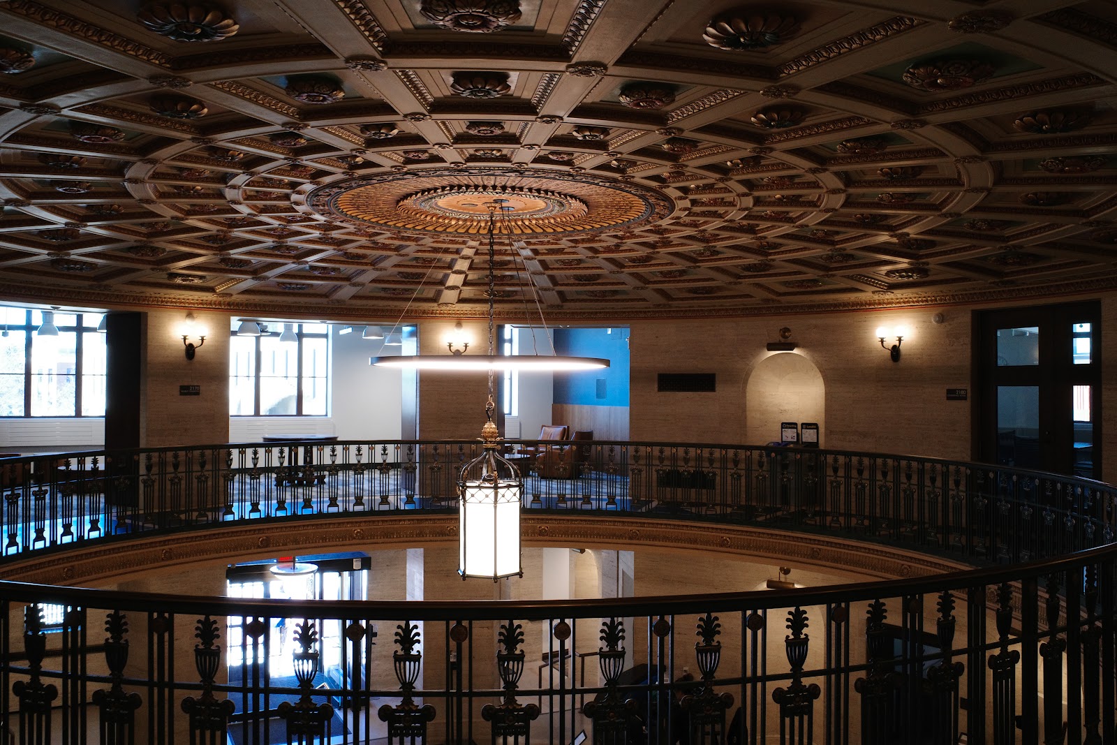 View of interior ceiling molding and chandelier from upper balcony in Ruthven Hall.
