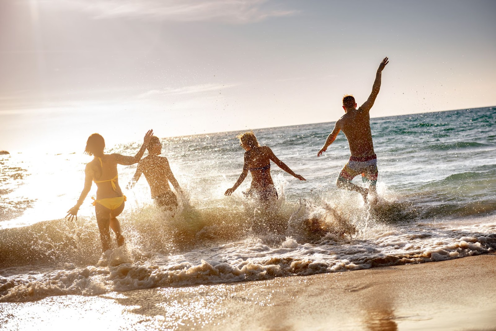 Grupo de jovenes disfrutando de la playa en su cumpleaños