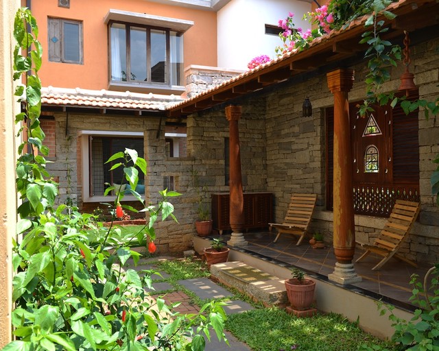 A peaceful courtyard with wooden chairs and potted plants reflects traditional architecture.