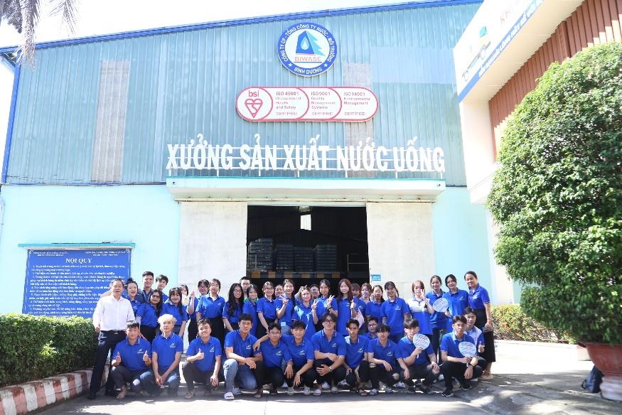 A group of people in blue shirts posing for a photoDescription automatically generated