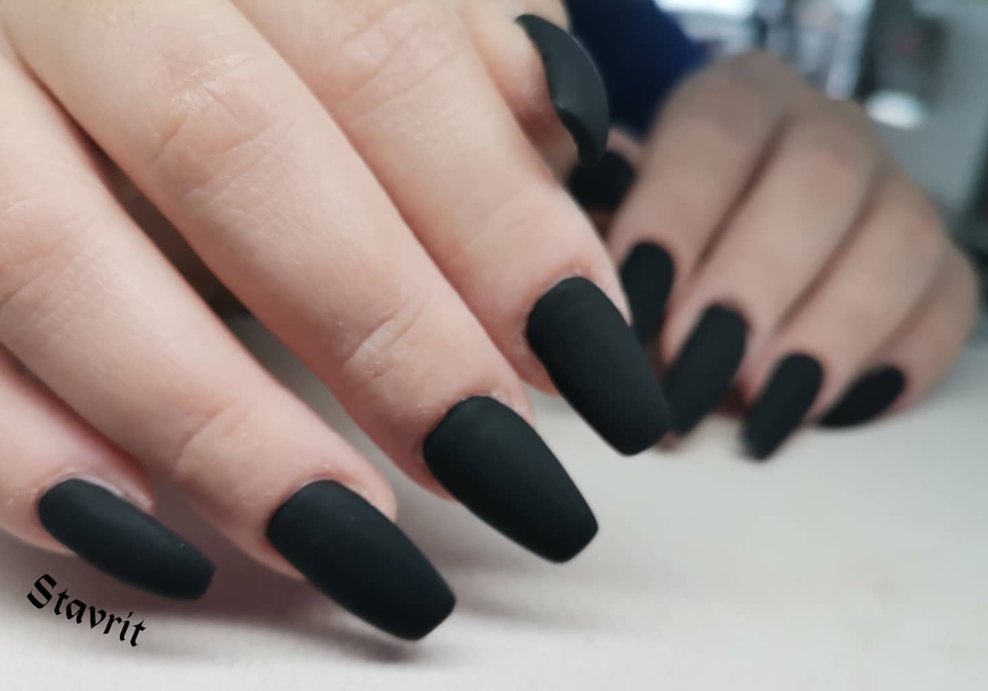 Close-up of a person's hands with black nails having Black Velvet Nails