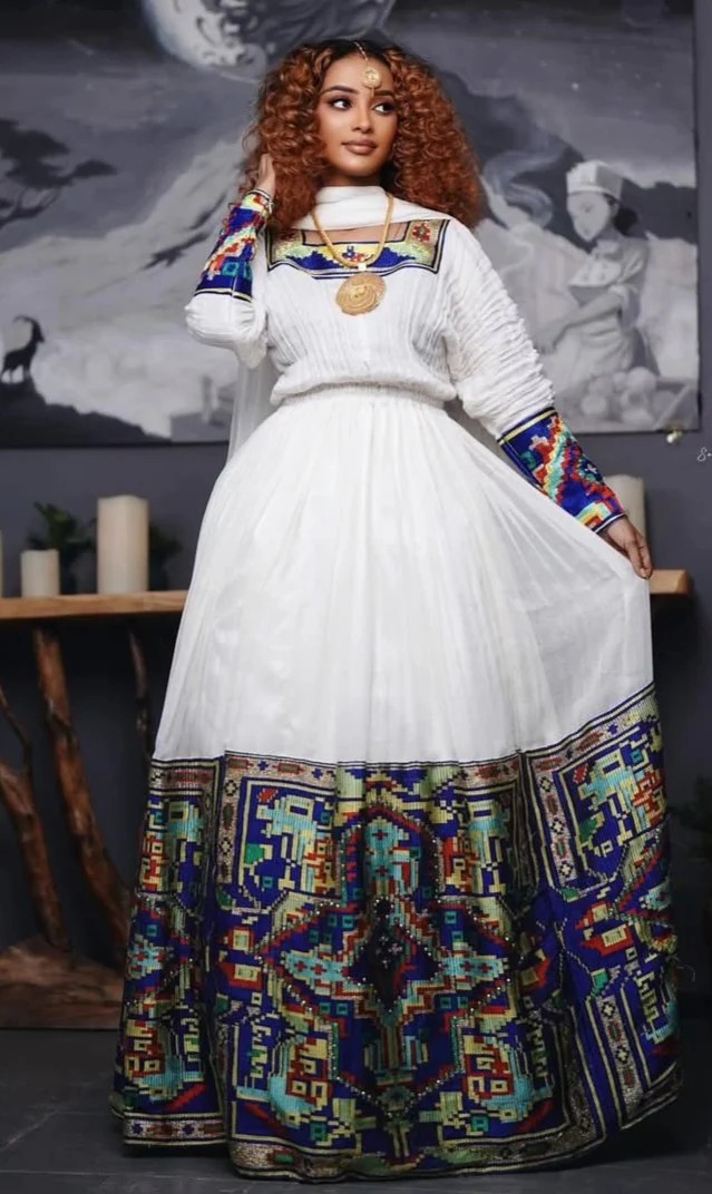 Modern Habesha dress for diaspora women featuring colourful traditional embroidery on a white dress with contemporary design