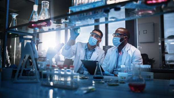 two-scientists-in-laboratory-wearing-masks-analyzing-liquid-in-flask-surrounded-by-lab-equipment-and-chemical-glassware-bronchogen-and-peptides-stack-how-to-rebuild-recover-and-outlast-the-normies-tony-huge