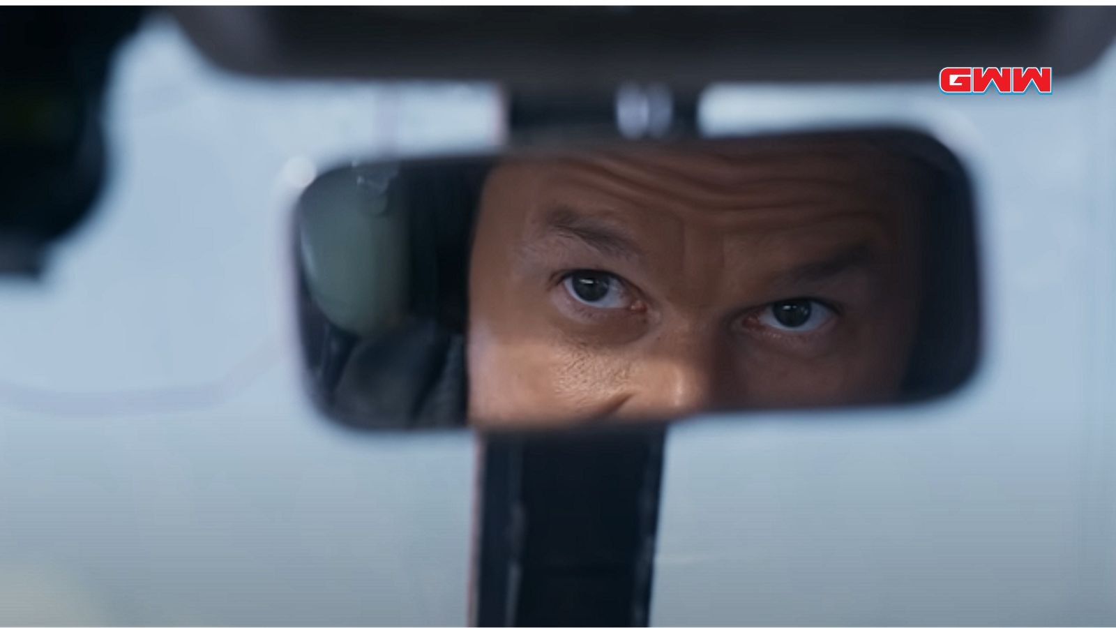 Mark Wahlberg focused on flying, seen through the rearview mirror.