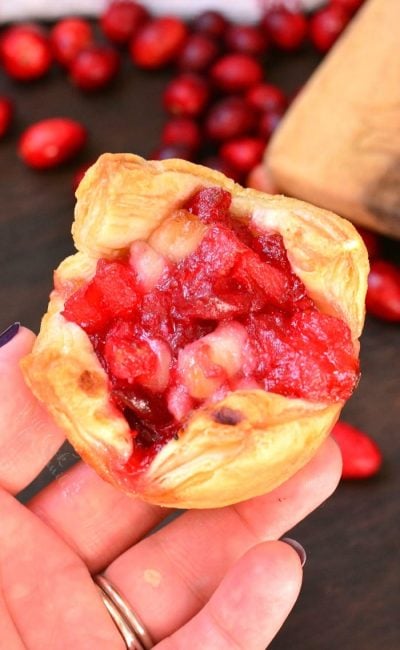 holding one apple cranberry brie puff closeup