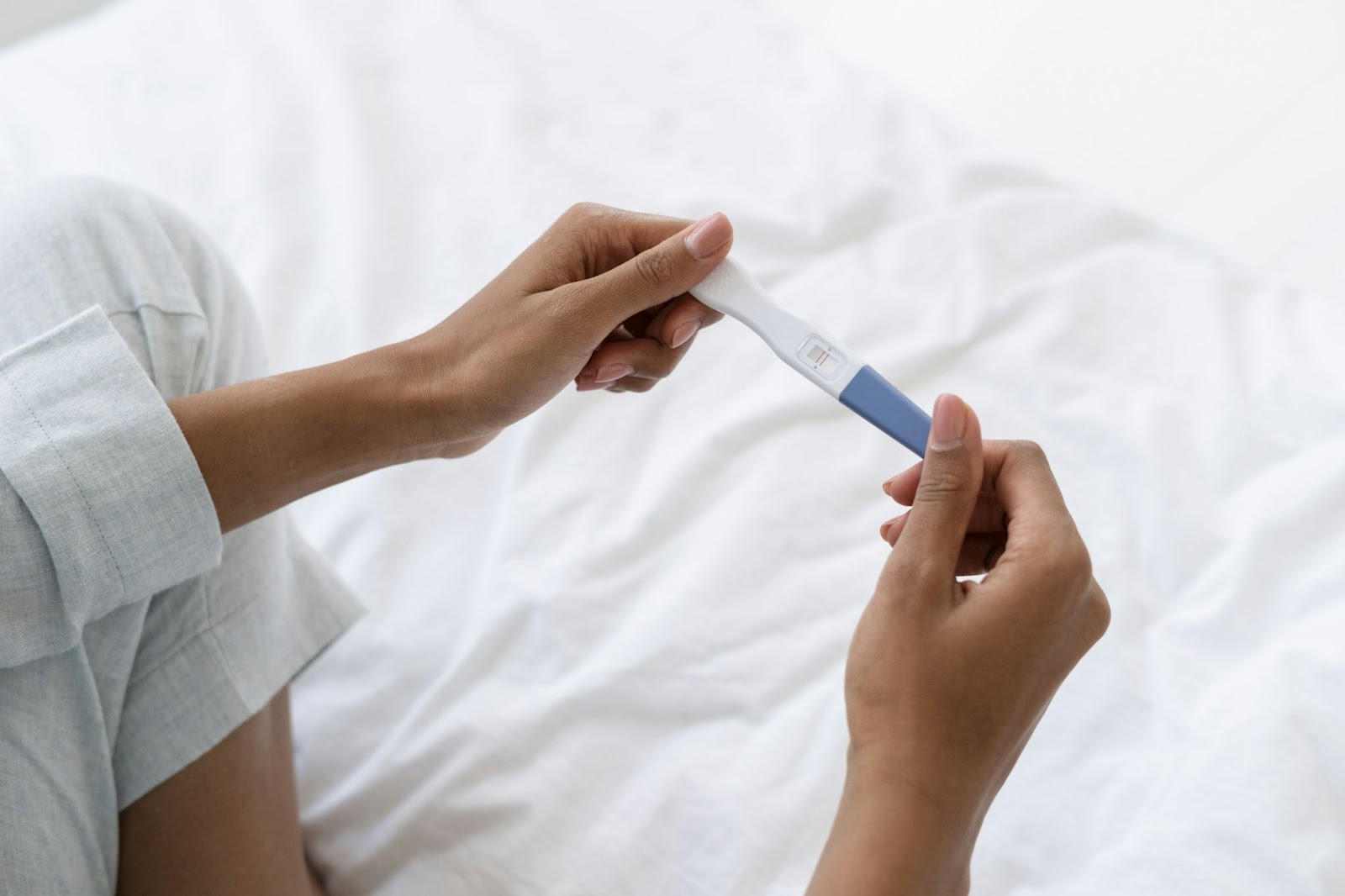 A female looking at a pregnancy test.