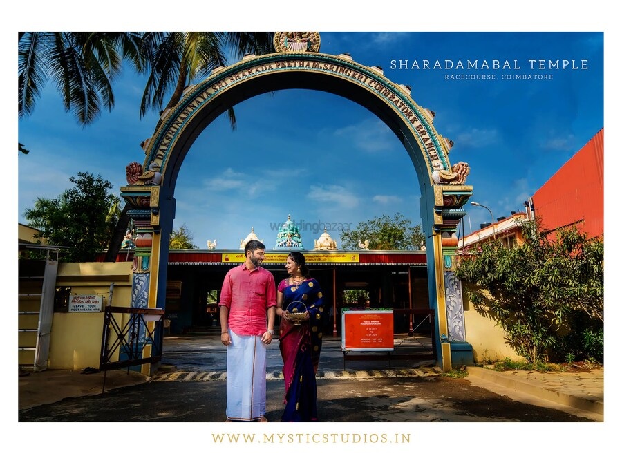 Couple in traditional attire standing before Coimbatore's cultural landmarks for a historic photoshoot