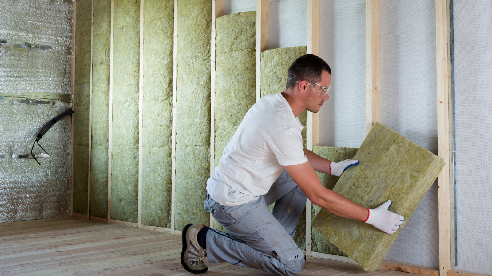 Man installing wall insulation | Shush! A Guide to Acoustic Insulation | Insulation Merchant