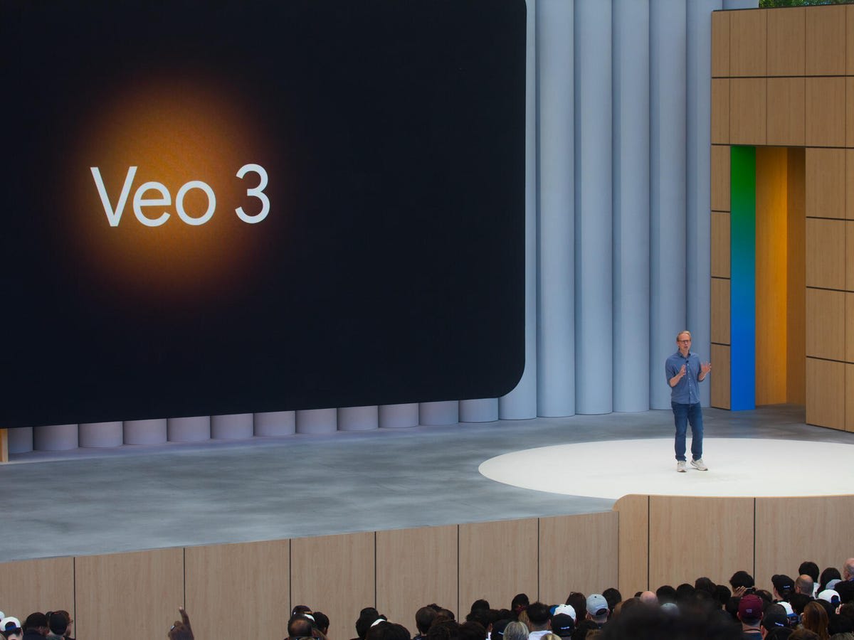 A presenter on stage with "Veo 3" displayed on a large screen during a presentation