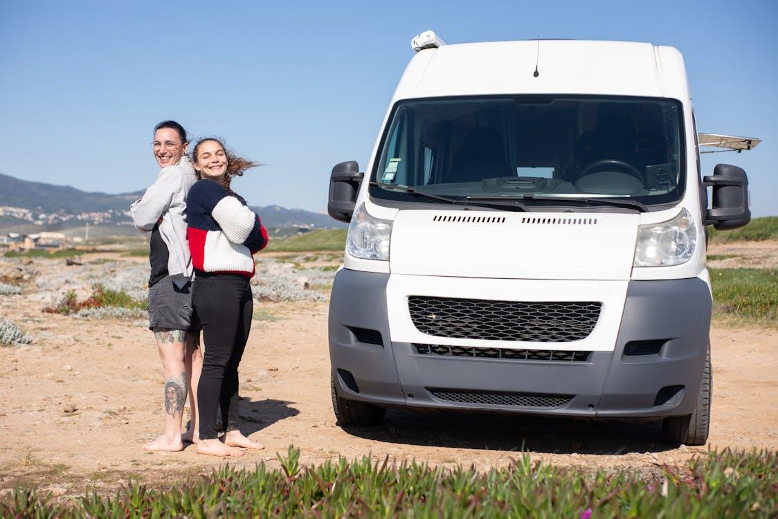 Free Couple Standing Back to Back Next to Their Van  Stock Photo