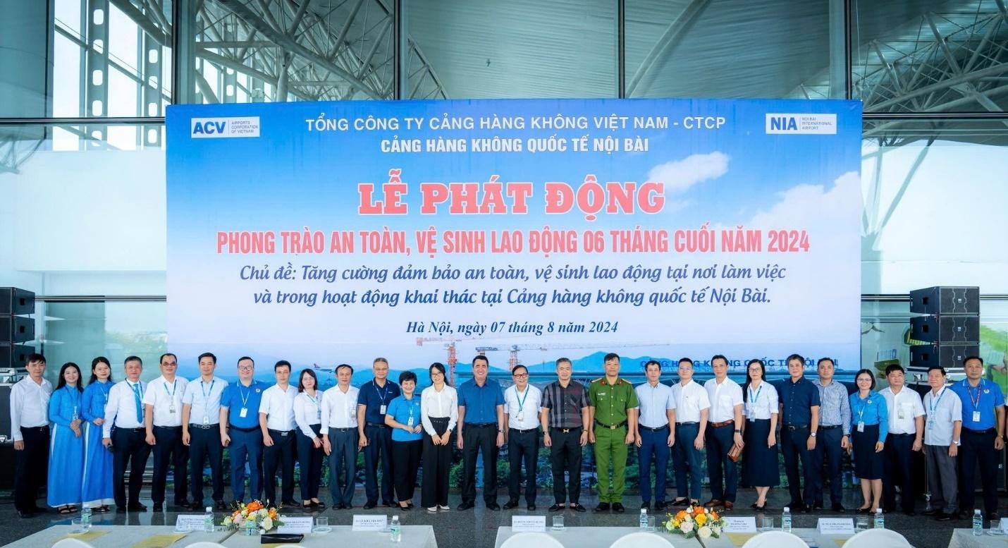 A group of people standing in front of a bannerDescription automatically generated