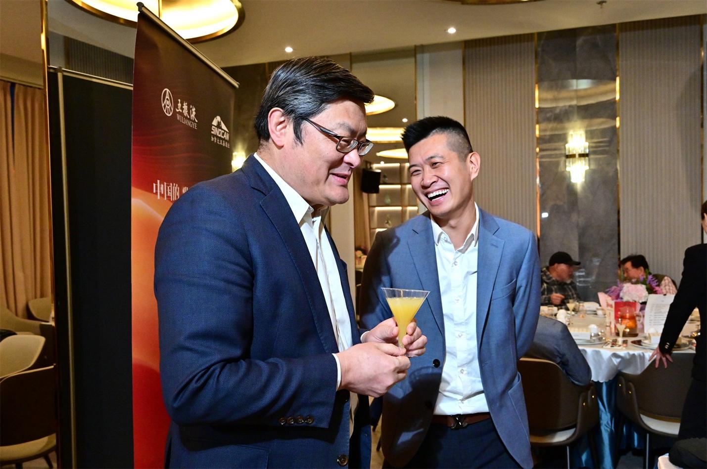 A couple of men smiling and holding a glass of liquid

AI-generated content may be incorrect.