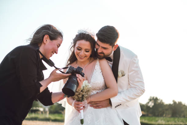 Wedding photographer showing the couple their beautiful wedding pictures, capturing the moment of excitement.