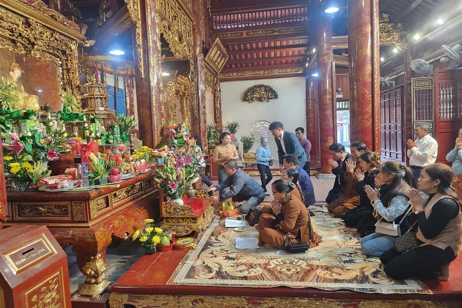 Tourists offer incense at the main hall