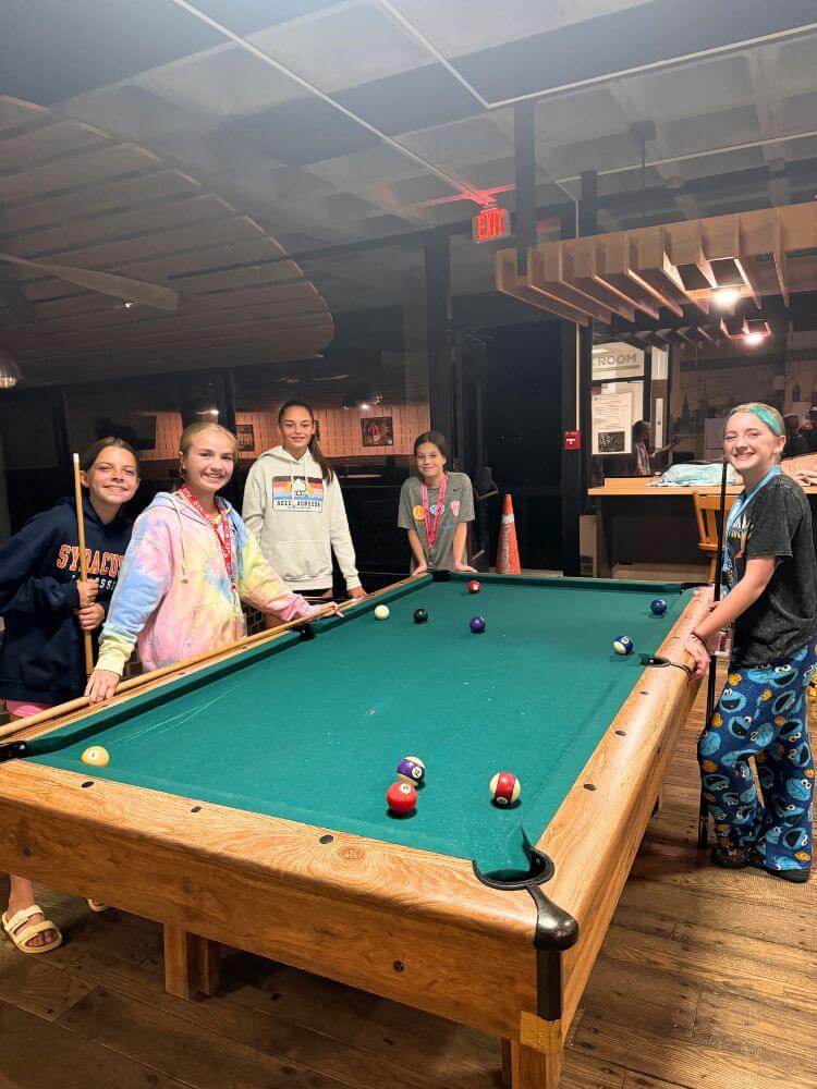 A group of girls enjoying a game of pool at signature sports camp