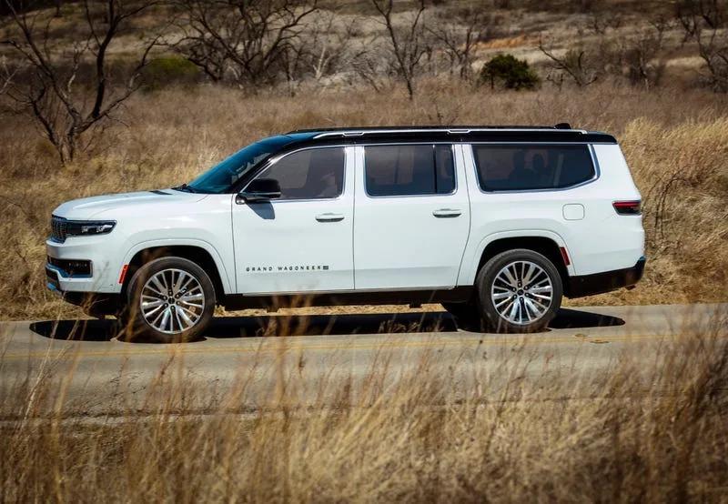 A white suv on a road

Description automatically generated