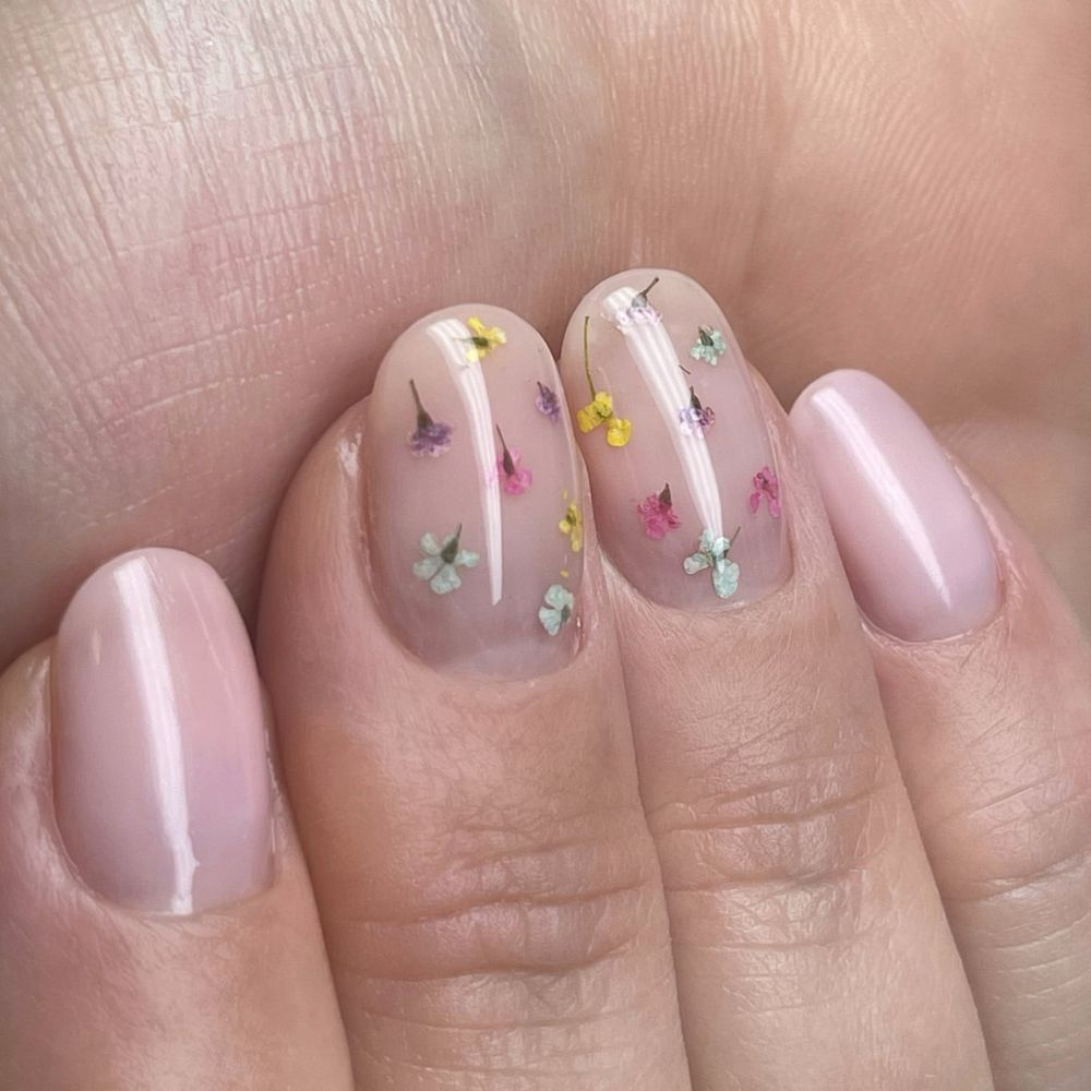 Close up of flowered short nail design with Tiny flowers on nude 