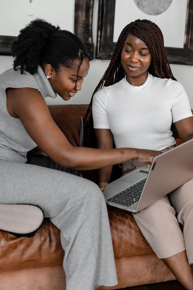 Alt Text: Two women using a laptop